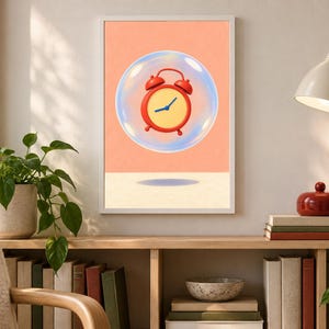 May include: A framed wall art print featuring a red analog alarm clock with a yellow face and blue hands floating inside a transparent bubble against a solid peach background, with a dark shadow cast on the light surface below the bubble.