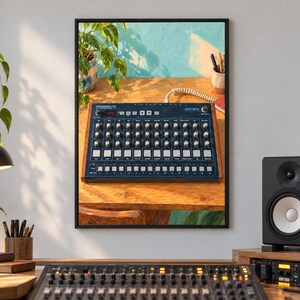 Puede incluir: Un cuadro decorativo enmarcado que muestra una caja de ritmos anal&oacute;gica Arturia DrumBrute de color azul oscuro con paneles laterales de madera, situada sobre un escritorio de madera junto a una planta y un portal&aacute;pices ante una pared azul.