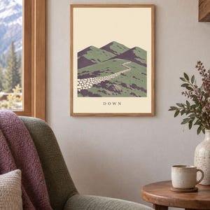Pu&ograve; includere: Una stampa artistica incorniciata che presenta un'illustrazione paesaggistica stilizzata di colline verdi e un muro di pietra che si snoda in lontananza. La parola DOWN &egrave; stampata in lettere maiuscole nere al centro in basso su sfondo crema.