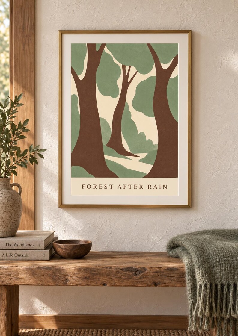 May include: A framed wall art print featuring a stylized forest scene with brown tree trunks and sage green foliage against a cream background. The text FOREST AFTER RAIN is printed in black at the bottom of the illustration within the frame.