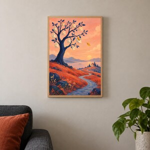 Op de afbeelding: Een ingelijste verticale wandkunstprint met een landschap met een grote donkerblauwe boom waaraan witte enveloppen hangen. Een kronkelend pad leidt door rode grasheuvels naar een klein huis bij een meer tijdens een zonsondergang.