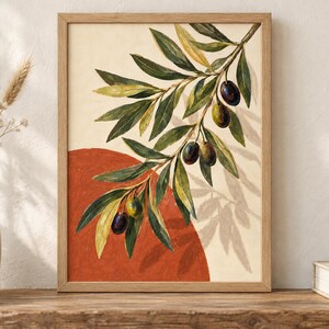 May include: A framed wall art print featuring a watercolor illustration of an olive branch with green and dark purple olives. The branch is set against a cream background with a large, solid terracotta-colored circle behind the foliage.