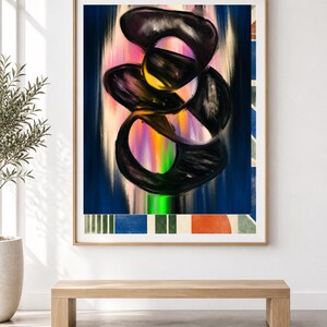 Op de afbeelding: Een ingelijst rechthoekig wandkunstwerk met een centrale abstracte compositie van in elkaar grijpende zwarte organische vormen, gelaagd over een verticaal verloop van roze, geel en blauw. De onderste rand toont een patroon van blauwe, groene en oranje blokken.