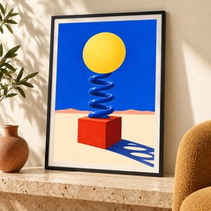 Puede incluir: Una l&aacute;mina art&iacute;stica enmarcada que muestra un paisaje surrealista con un cubo rojo sobre un suelo des&eacute;rtico beige. Un muelle azul en espiral se asienta sobre el cubo, sosteniendo una gran esfera amarilla bajo un cielo azul intenso. Incluye una sombra.