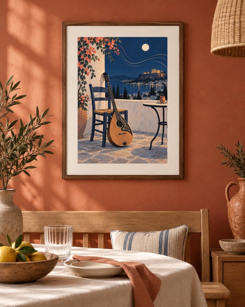 Pu&ograve; includere: Una stampa artistica incorniciata raffigurante una scena notturna su un balcone con un bouzouki in legno appoggiato a una sedia blu. L'illustrazione presenta una terrazza in pietra, un tavolino rotondo, una pianta rampicante e una fortezza illuminata.
