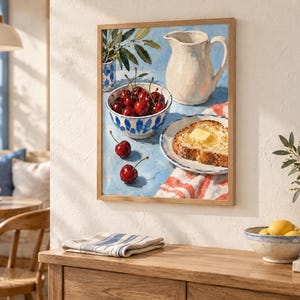 May include: A framed oil painting depicting a still life scene on a light blue surface. The composition features a white ceramic pitcher, a bowl filled with red cherries, two loose cherries, and a slice of toasted bread topped with butter.