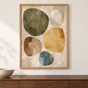 May include: A framed vertical wall art piece featuring five large, rounded, organic shapes in shades of olive green, mustard yellow, brown, blue, and off-white, set against a textured, neutral-toned background with visible brushstroke details.
