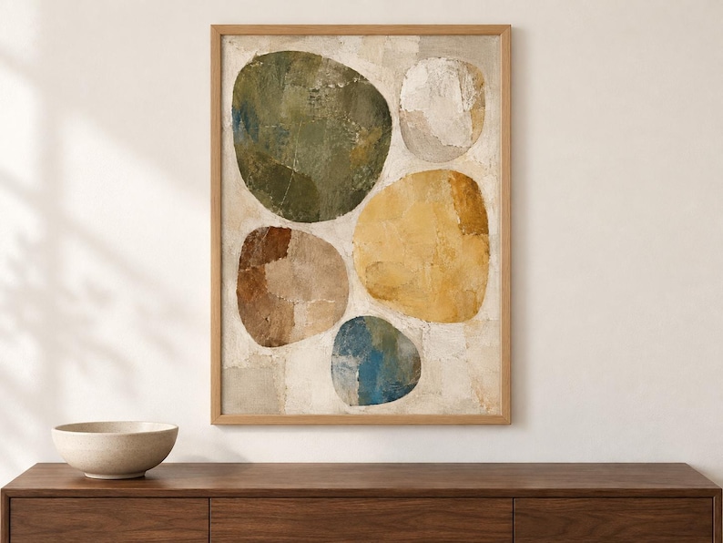 May include: A framed vertical wall art piece featuring five large, rounded, organic shapes in shades of olive green, mustard yellow, brown, blue, and off-white, set against a textured, neutral-toned background with visible brushstroke details.