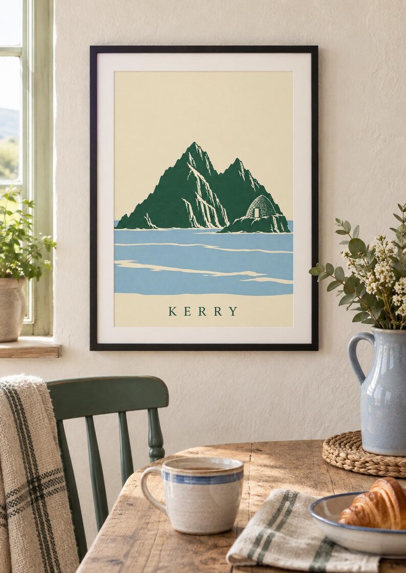 Pu&ograve; includere: Una stampa artistica incorniciata con un'illustrazione stilizzata delle isole Skellig in Irlanda. L'opera mostra montagne frastagliate verde scuro e una capanna di pietra a forma di alveare su sfondo crema e mare azzurro, con il testo KERRY.