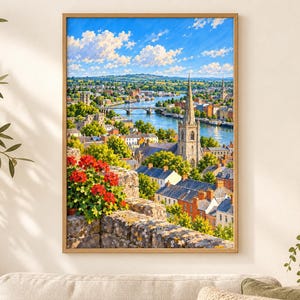 May include: A framed vertical wall art print depicting a scenic town landscape with a river, a stone church spire, and lush green trees under a bright blue sky with white clouds. In the foreground, vibrant red flowers bloom on a stone wall.