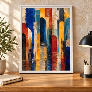 May include: A framed abstract painting featuring vertical rectangular and arched shapes in vibrant shades of blue, yellow, red, and white. The composition includes textured brushstrokes and color blocks that create a sense of depth and layered architectural forms, with a reflective quality at the bottom of the canvas.