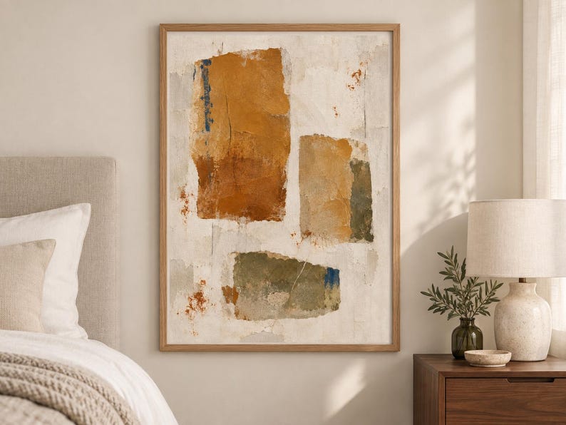 May include: A framed rectangular wall art piece featuring an abstract composition of three distinct, textured blocks in shades of ochre, burnt orange, and muted olive green against a neutral, off-white background with subtle paint splatters.
