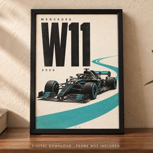 May include: A framed poster featuring a black Mercedes W11 Formula 1 race car with teal accents on a light background. The text reads MERCEDES W11 and 2020 in bold black lettering. A teal curved line represents a track path on the lower portion.