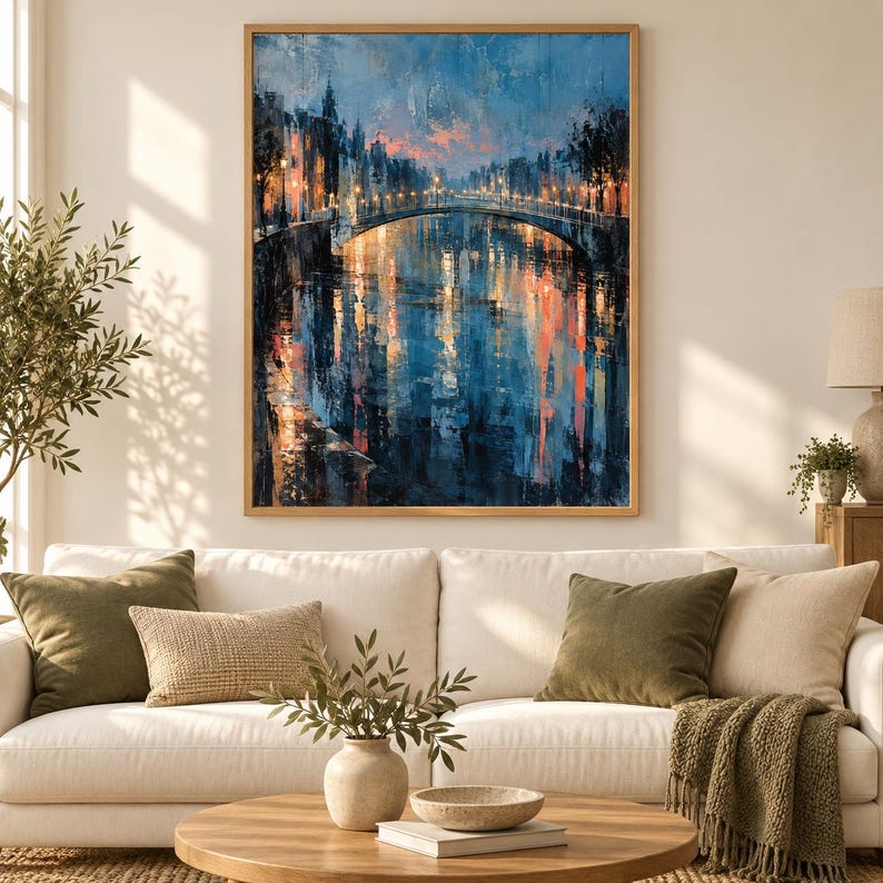Op de afbeelding: Een rechthoekige wandkunstprint met een impressionistisch olieverfschilderij van een stadsgracht bij schemering. De sc&egrave;ne toont een stenen brug verlicht door warme gouden straatlantaarns, met levendige blauwe en oranje reflecties op het water.