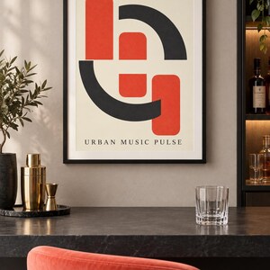 May include: A framed wall art print featuring a cream background with a geometric design of two vertical red rectangles and two black curved shapes. The text URBAN MUSIC PULSE is printed in black at the bottom of the composition within the frame.