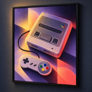 K&ouml;nnte beinhalten: Ein gerahmter Wandkunstdruck, der eine hellgraue Retro-Videospielkonsole und einen passenden Controller mit schwarzem Kabel zeigt. Die Konsole verf&uuml;gt &uuml;ber einen Power-Knopf, eine Auswurftaste, eine Reset-Taste und ein buntes Logo.