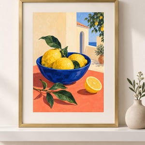May include: A framed art print depicting a vibrant blue bowl filled with yellow lemons and green leaves resting on an orange surface. The background shows a Mediterranean-style building with an arched doorway, a lemon tree, and a glimpse of the sea.