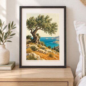 May include: A framed art print featuring a landscape painting of a gnarled olive tree perched on a rocky, golden-hued hillside overlooking a deep blue sea and distant coastline under a clear, pale sky, enclosed in a simple black frame.