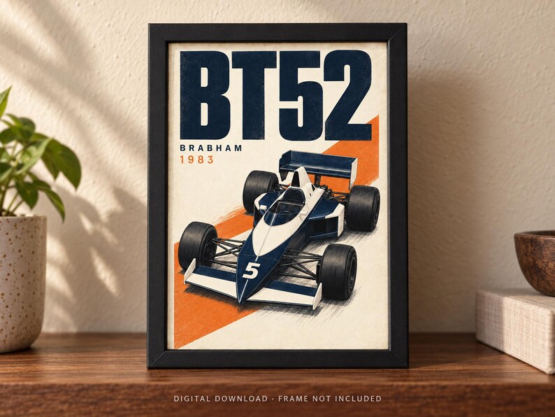 May include: A framed poster featuring a blue and white Brabham BT52 Formula One race car with the number 5 on the nose. The text BT52, BRABHAM, and 1983 are printed in bold blue and orange colors against a cream background with an orange diagonal stripe.