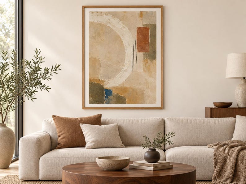 Puede incluir: Una impresi&oacute;n de arte mural abstracto enmarcada que presenta una gran pincelada circular blanca, un bloque rectangular de terracota y tonos tierra apagados de beige, verde oliva y azul profundo sobre un fondo texturizado, en un marco de madera clara.