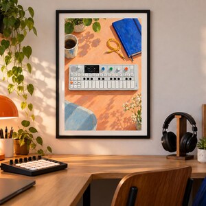 Pu&ograve; includere: Una stampa artistica da parete incorniciata che mostra una vista dall'alto di un sintetizzatore portatile bianco con manopole colorate, un taccuino blu, un cavo audio giallo e una tazza su una superficie arancione, esposta in una stanza con scrivania, lampada e cuffie.