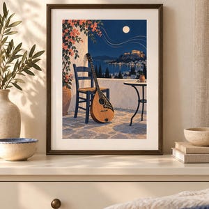 Pu&ograve; includere: Una stampa d'arte incorniciata raffigurante una scena notturna su un balcone con un bouzouki in legno appoggiato a una sedia blu. La vista include una terrazza in pietra, un tavolino, fiori arancioni, una costa illuminata e la luna piena.