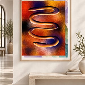 Puede incluir: Una impresi&oacute;n de arte mural enmarcada que presenta una forma central oscura, sinuosa y en forma de S sobre un fondo texturizado vibrante de tonos mezclados de naranja, rojo, amarillo y violeta intenso. La obra est&aacute; en un marco de madera clara.
