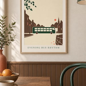 May include: A framed wall art print featuring a stylized illustration of a dark green double-decker bus driving through a town at sunset. The scene includes brown silhouettes of buildings, a street lamp, and the text "EVENING BUS RHYTHM" at the bottom.