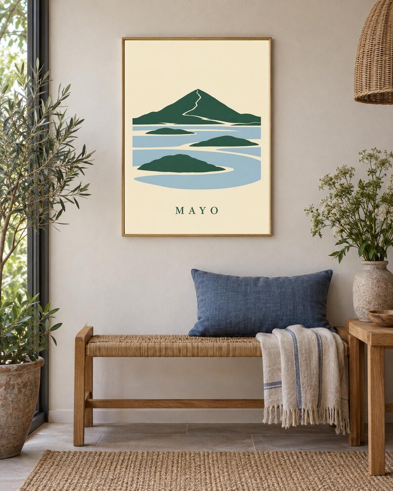 Pu&ograve; includere: Una stampa artistica da parete incorniciata che presenta un'illustrazione paesaggistica stilizzata di una montagna e isole circondate dall'acqua. Il design utilizza una tavolozza di verde scuro, azzurro e crema. La parola MAYO &egrave; stampata in basso.