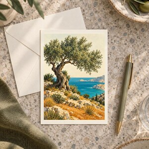 May include: A rectangular greeting card featuring a detailed illustration of a gnarled olive tree perched on a rocky, sun-drenched hillside overlooking a vibrant blue sea with distant coastal cliffs under a clear, pale sky.
