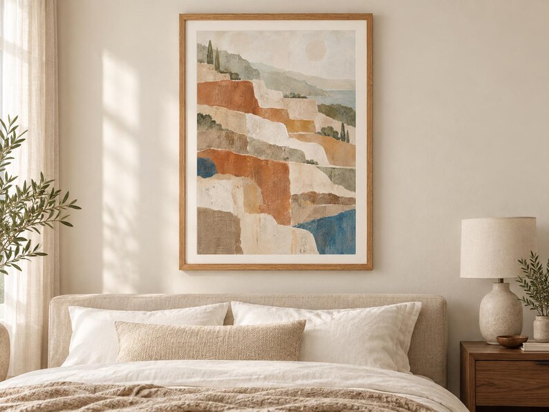 Op de afbeelding: Een ingelijste wandkunstprint met een landschapsillustratie van gelaagde, terrasvormige heuvels in tinten terracotta, cr&egrave;me en gedempt groen, geaccentueerd door donkerblauwe vlakken en slanke cipressen onder een bleke, zachte zon.