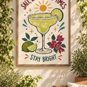 May include: A framed wall art print featuring a margarita in a glass with a salted rim, a lime wedge, and ice cubes. The text reads SALT, CITRUS, GOOD TIMES and STAY BRIGHT. The illustration includes a yellow sun, green limes, and pink flowers.