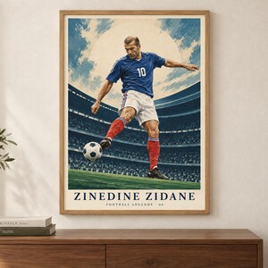 Puede incluir: Un p&oacute;ster enmarcado que muestra a un jugador de f&uacute;tbol con camiseta azul con el n&uacute;mero 10, pantalones cortos blancos y calcetines rojos pateando un bal&oacute;n. El fondo muestra un estadio con un gran sol. El texto dice ZINEDINE ZIDANE FOOTBALL LEGENDS 06.