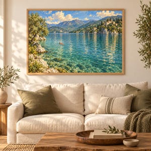 May include: A rectangular landscape wall art print featuring a clear turquoise lake surrounded by rocky cliffs and distant mountains under a bright blue sky with white clouds. A small person is swimming in the center of the calm, sunlit water.