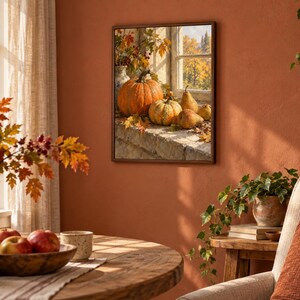 May include: A square framed wall art print depicting a still life scene of orange pumpkins and yellow pears resting on a stone windowsill. The image shows autumn foliage and a window view of trees, rendered in warm, seasonal colors and textures.