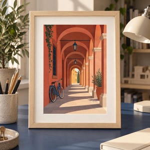 Pu&ograve; includere: Una stampa artistica incorniciata che mostra una vista in prospettiva di un porticato color terracotta. Una bicicletta blu &egrave; appoggiata contro una parete coperta di piante rampicanti. Lanterne sospese illuminano il corridoio verso l'esterno.