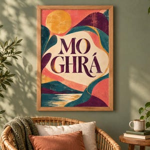 May include: A rectangular framed wall art print featuring a stylized landscape with a yellow sun, dark purple mountains, and teal hills. The text MO GHR&Aacute; is printed in large, dark purple serif letters in the center against a cream-colored background.