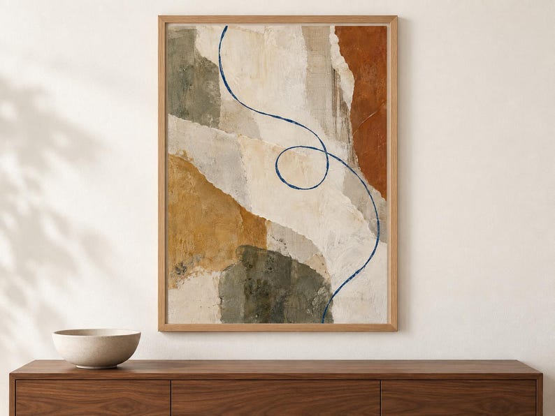 Puede incluir: Una l&aacute;mina de arte mural abstracto enmarcada con formas superpuestas estilo papel rasgado en tonos crema, beige, terracota y verde oliva. Una l&iacute;nea fina, continua y de color azul oscuro se curva y forma un bucle en el centro.