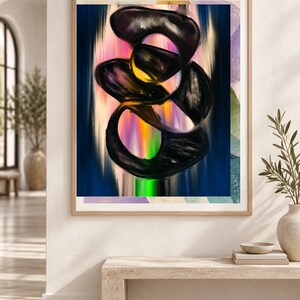 Op de afbeelding: Een ingelijste wandkunstprint met een abstracte compositie van dikke, wervelende zwarte penseelstreken over een levendige, verticale gradi&euml;ntachtergrond in roze, oranje, gele en groene tinten, geplaatst in een lichtgekleurde houten lijst.