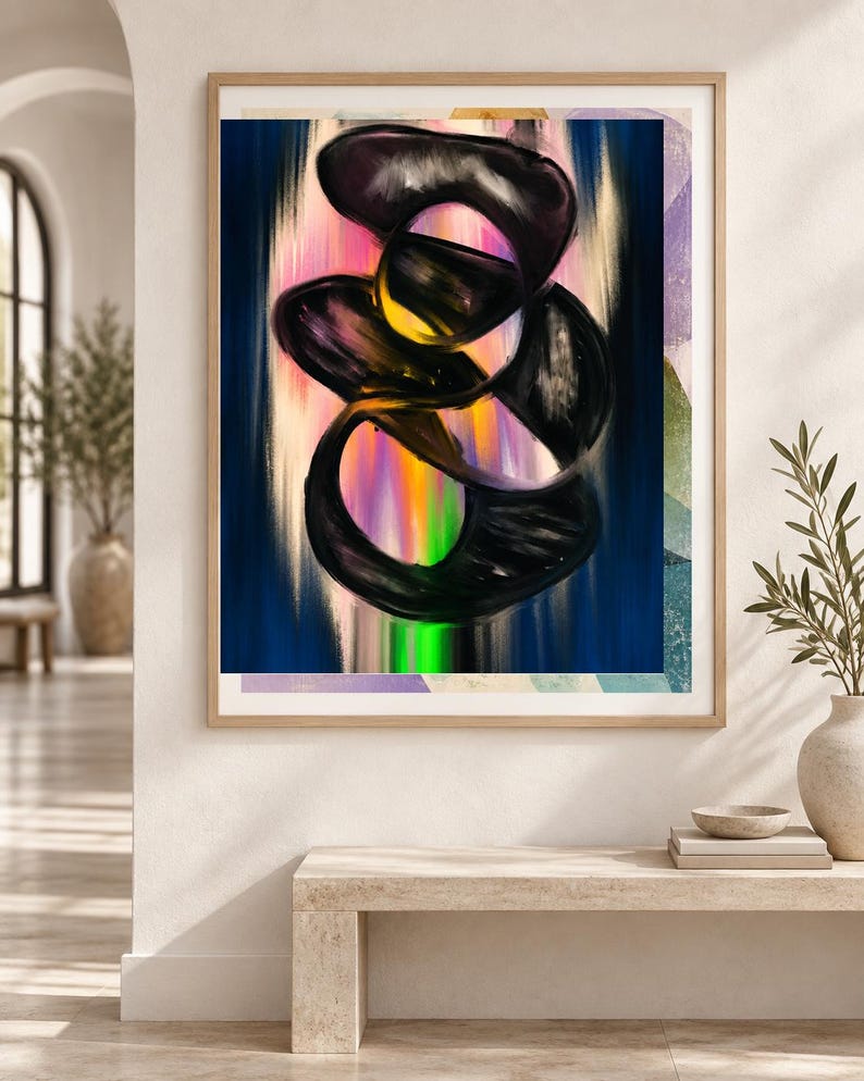 Op de afbeelding: Een ingelijste wandkunstprint met een abstracte compositie van dikke, wervelende zwarte penseelstreken over een levendige, verticale gradi&euml;ntachtergrond in roze, oranje, gele en groene tinten, geplaatst in een lichtgekleurde houten lijst.