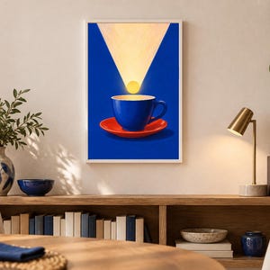 Puede incluir: Una l&aacute;mina de arte mural enmarcada que muestra una taza de caf&eacute; azul vibrante sobre un platillo rojo brillante. Una fuente de luz circular amarilla resplandece sobre la taza, proyectando un haz de luz triangular sobre un fondo azul.