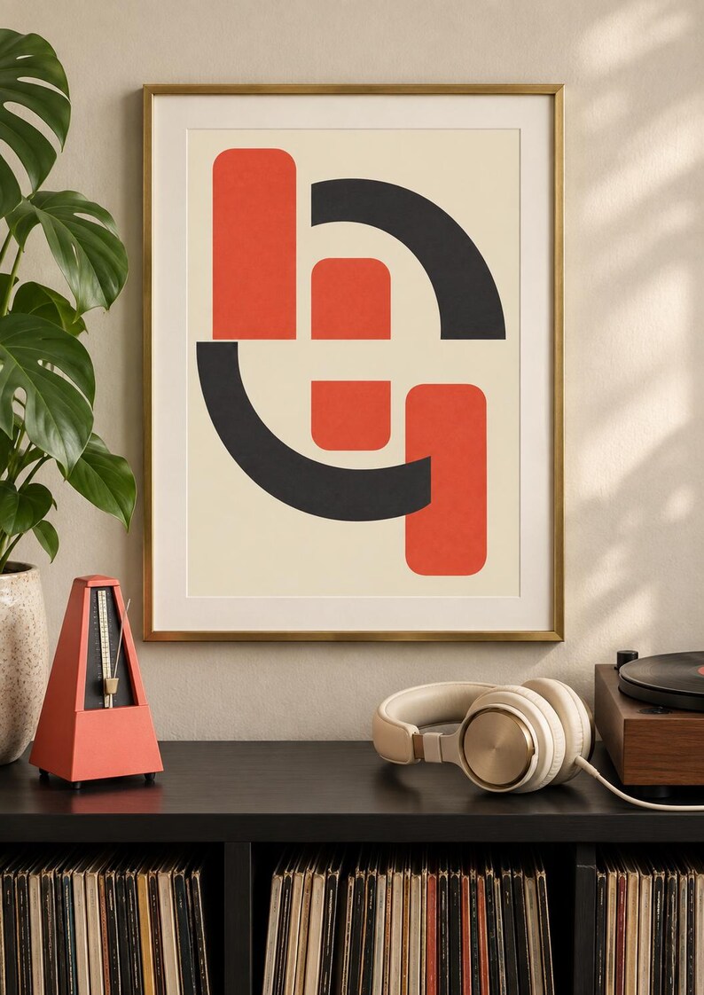 May include: A framed wall art print featuring a geometric composition of two vertical orange rectangles and two black curved arcs on a cream background. The artwork is enclosed in a thin gold-colored metal frame, displaying a balanced arrangement of shapes.