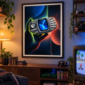 Puede incluir: Una l&aacute;mina de arte mural enmarcada que presenta una ilustraci&oacute;n estilizada de la consola port&aacute;til Nokia N-Gage. El dispositivo aparece en un entorno oscuro y brillante con vibrantes acentos de luz azul y roja, resaltando su teclado y pantalla.