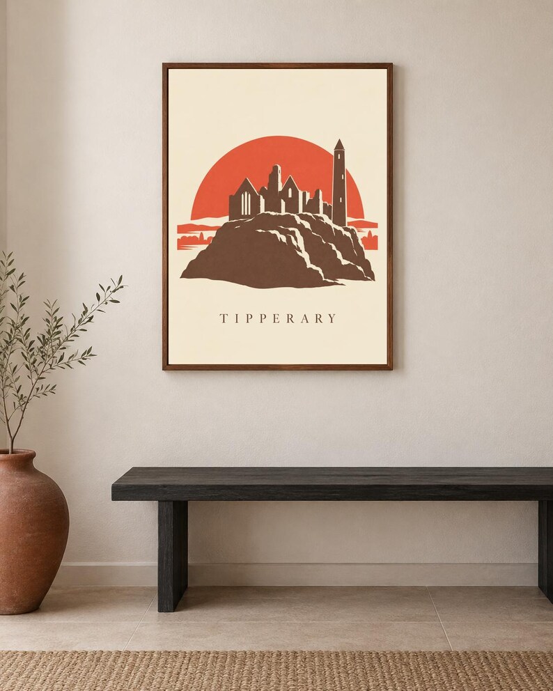 May include: A framed wall art print featuring a stylized illustration of the Rock of Cashel in Tipperary. The design shows a dark brown silhouette of the stone ruins against a large, solid orange sun on a cream background with the text TIPPERARY.