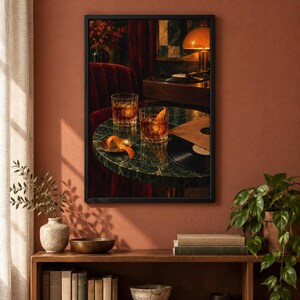 May include: A framed wall art print depicting two crystal glasses filled with amber liquid and orange peels on a round green marble table. A black vinyl record, a record player, and a warm lamp are visible in the background of the scene.
