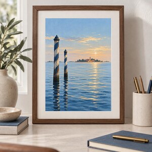 May include: A framed art print depicting a serene seascape with two blue and white striped mooring poles in the foreground. The background features a distant island with buildings under a soft sunset sky, with light reflecting on the water surface.
