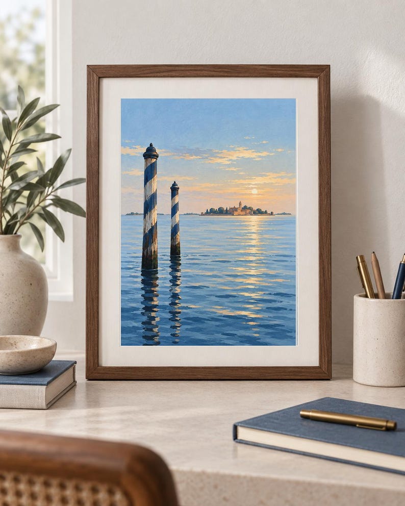 May include: A framed art print depicting a serene seascape with two blue and white striped mooring poles in the foreground. The background features a distant island with buildings under a soft sunset sky, with light reflecting on the water surface.