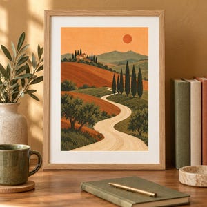 K&ouml;nnte beinhalten: Ein gerahmter Kunstdruck mit einer Landschaftsillustration eines gewundenen Feldwegs durch h&uuml;gelige Landschaften, Zypressen und eine entfernte Villa unter einem warmen orangefarbenen Himmel mit einer runden Sonne, in einem hellen Holzrahmen.