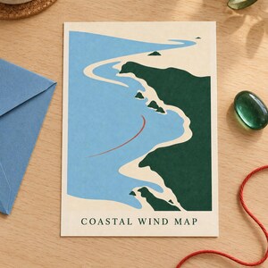 May include: A rectangular print titled COASTAL WIND MAP featuring a stylized illustration of a coastline with dark green land, light beige sandy shores, and a light blue ocean. A thin red curved line indicates wind direction across the water.
