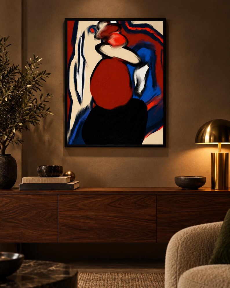 May include: A framed abstract painting featuring bold, expressive brushstrokes in vibrant red, deep blue, stark white, and solid black. The composition displays organic, rounded shapes and fluid lines that create a dynamic visual contrast.